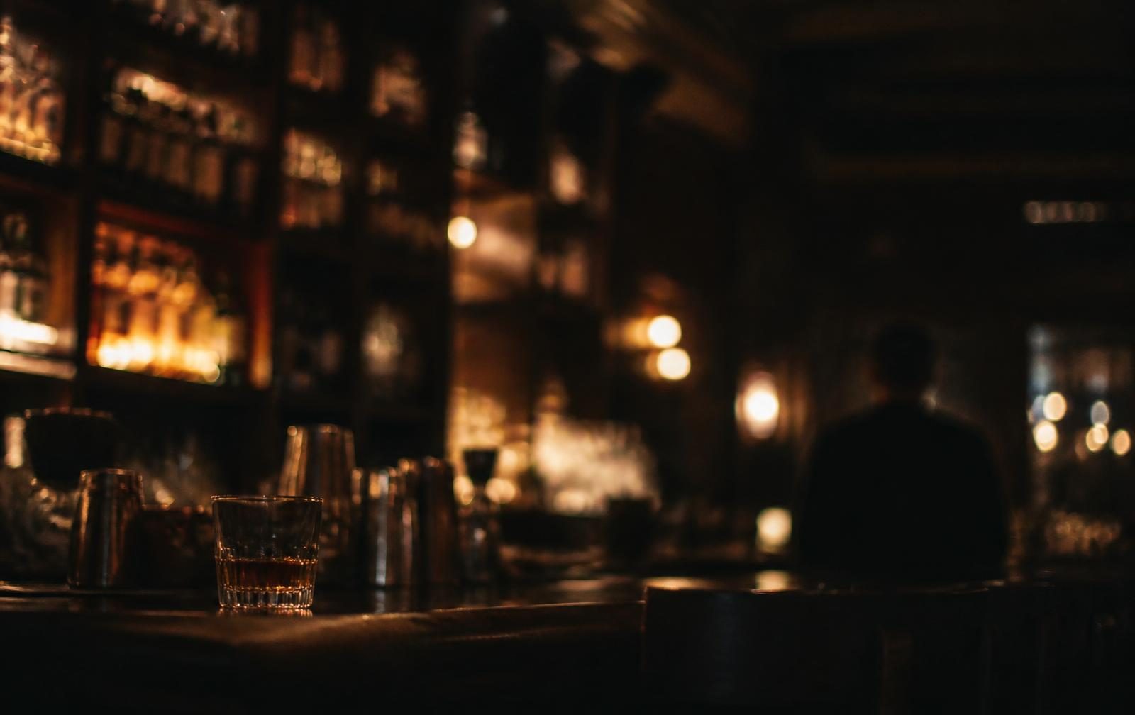 A dim bar interior, amber light out of focus