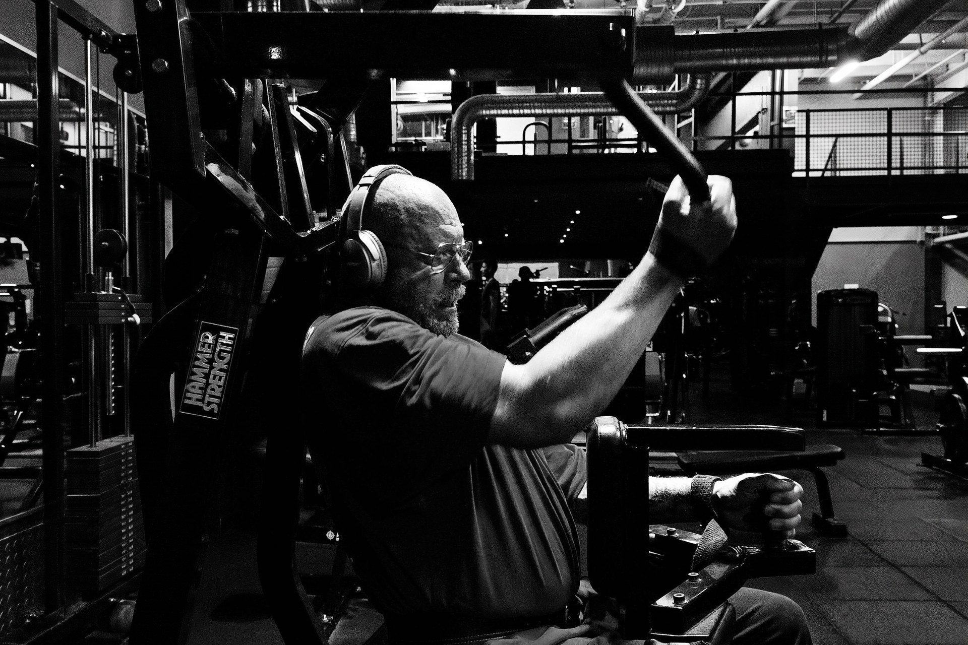 Black and white photograph of Tomas training on a HAMMER strength machine.